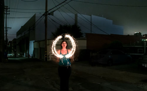 Woman standing in city at night