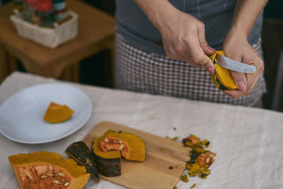 Close-up of hand holding fruit on table