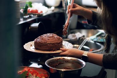 Midsection of woman preparing chocolate cake