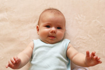 Portrait of cute baby lying down on bed