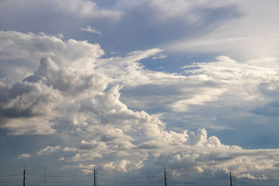 Low angle view of electricity pylon against dramatic sky