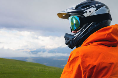 Portrait of an unrecognizable male cyclist against the backdrop of clouds and mountains. a man in a