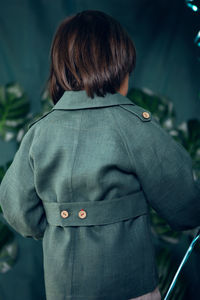 Boy child traveler in a hat stand wooden boxes in a studio on a green background