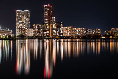 Illuminated buildings against sky at night