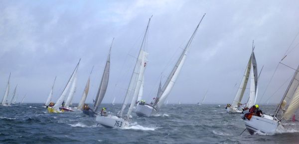 People sailing in sea against sky