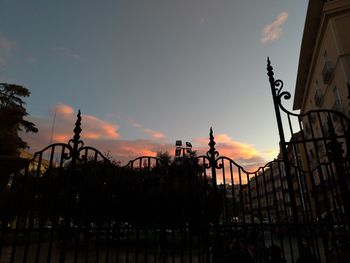Low angle view of silhouette bridge and buildings against sky during sunset