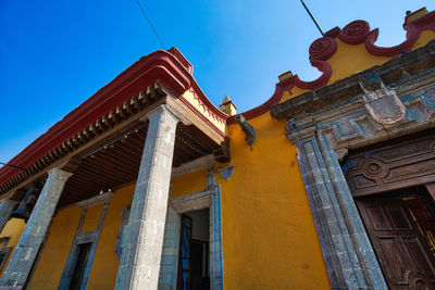 Low angle view of old building against clear blue sky