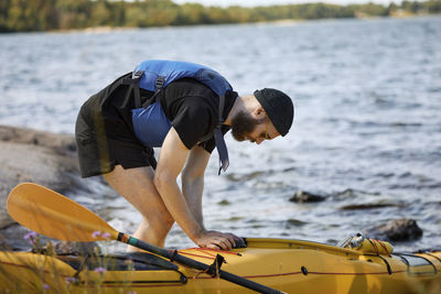 Man at sea standing near kayak