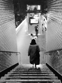 Rear view of people walking on staircase