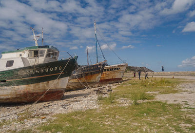 Sailboats moored on beach against sky