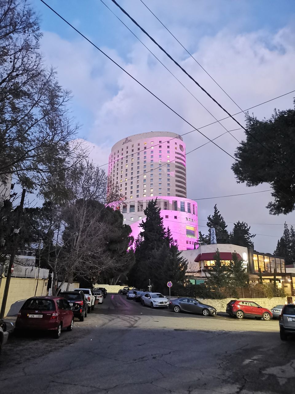 CARS ON ROAD AMIDST BUILDINGS AGAINST SKY