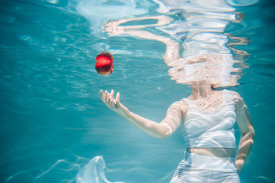 Rear view of woman swimming in pool