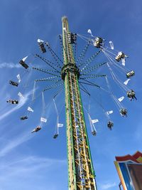 Low angle view of ferris wheel against blue sky