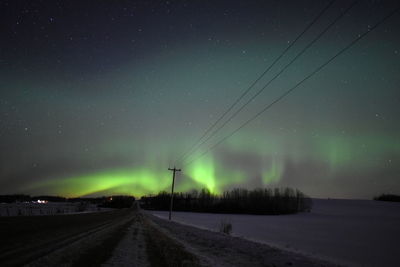 Scenic view of road against sky at night during winter