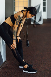 Full length of woman resting at gym