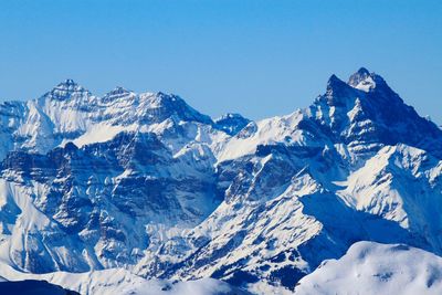 Scenic view of snowcapped mountains against clear blue sky