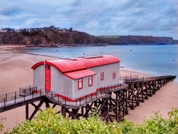 Renovated lifelifeboat station on beach against sea and sky. residential house.