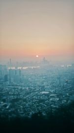 Aerial view of cityscape against sky during sunset