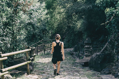 Girl walking along a small path in the mountain of sadernes, spain. on a sunny summer day