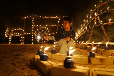 Man holding illuminated lighting equipment at night