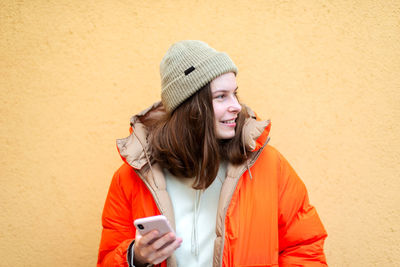 Mid adult woman using mobile phone in snow