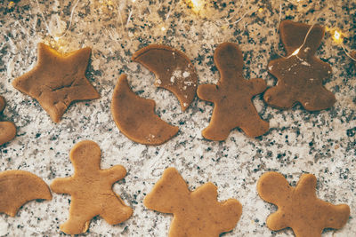 Making christmas cookies. figured gingerbread cookies on the kitchen table with holiday lights