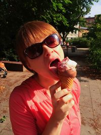 Portrait of young woman holding sunglasses