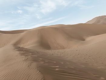 Sand dunes in desert against sky