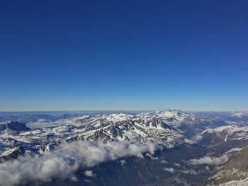 Scenic view of snowcapped mountains against clear blue sky