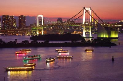 Illuminated view of tokyo bay and rainbow bridge at sunset
