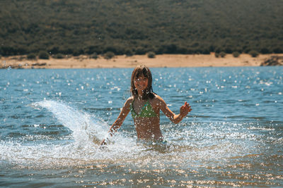 Rear view of woman standing at beach