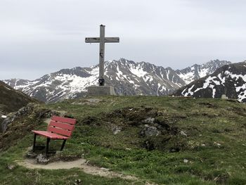 Traditional windmill on field by mountains against sky