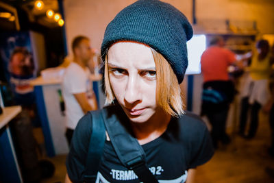 Portrait of young woman wearing hat in corridor