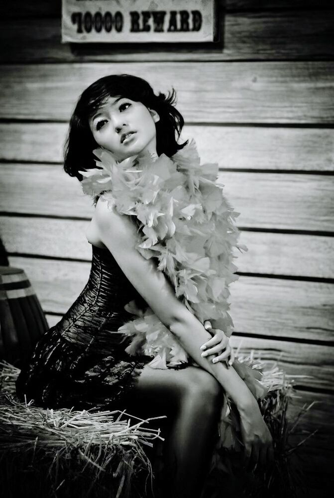 PORTRAIT OF BEAUTIFUL YOUNG WOMAN SITTING ON WOOD