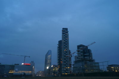 Illuminated cityscape against sky at night