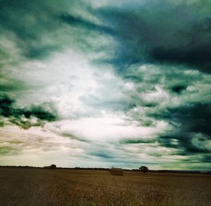 Scenic view of field against cloudy sky