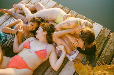 High angle view of young people laying on jetty