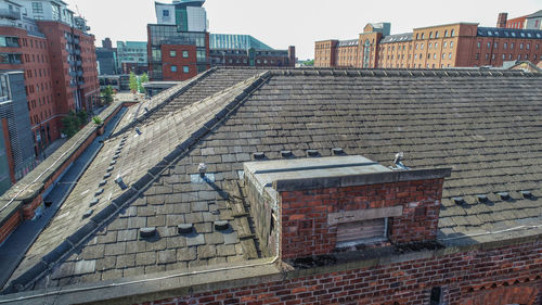Brick wall of building in city against sky