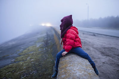 Rear view of woman on rock in snow