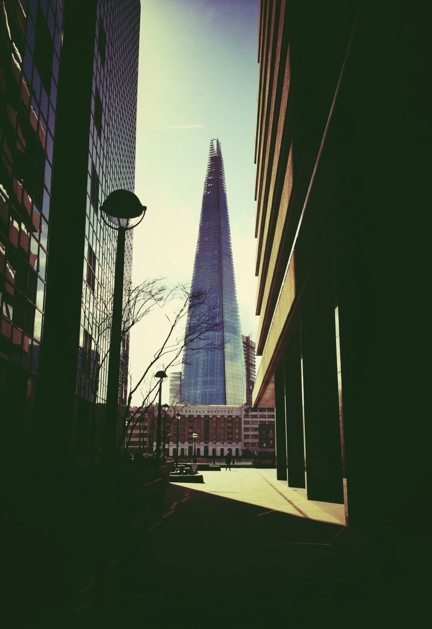 architecture, built structure, building exterior, low angle view, city, building, sky, modern, office building, day, tall - high, outdoors, the way forward, sunlight, no people, glass - material, tower, shadow, skyscraper, window