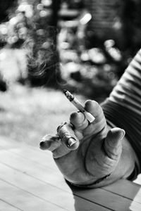 Close-up of hand holding cigarette