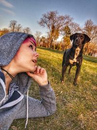 Portrait of woman with dog on field