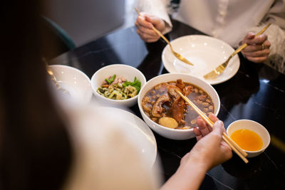 Midsection of woman holding food on table