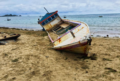 Abandoned boat moored on beach