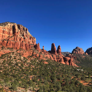 Rock formations on mountain against blue sky