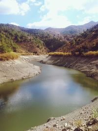 Scenic view of river against cloudy sky