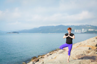 Full length of man standing on rock against sky