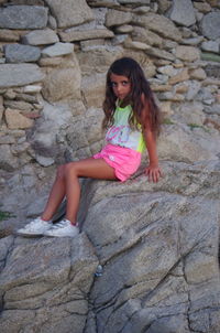 Portrait of girl sitting on rock