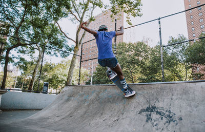 Full length of man jumping against trees