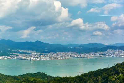 High angle view of townscape by sea against sky